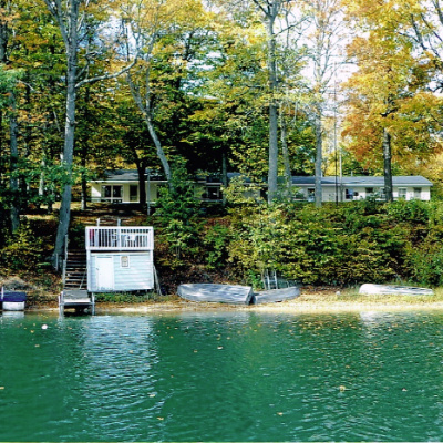 Kabin Dixon Lake Resort dilihat dari danau, dengan perahu memancing di tepi pantai